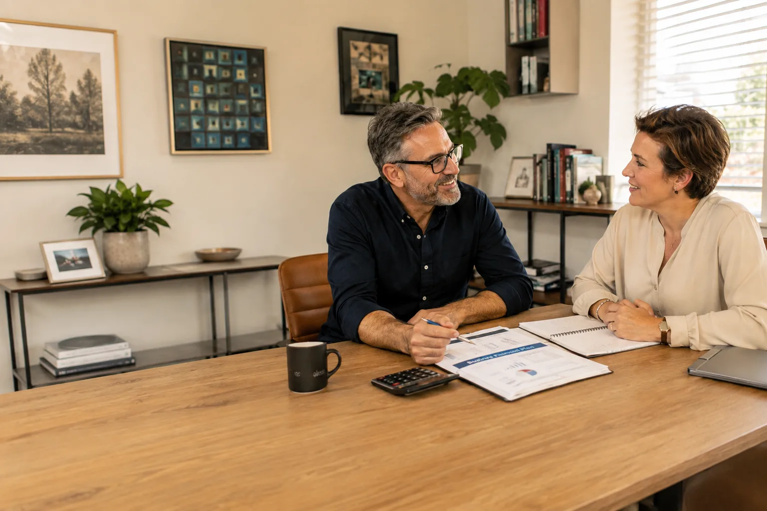 Two professionals talking over a business plan at a table